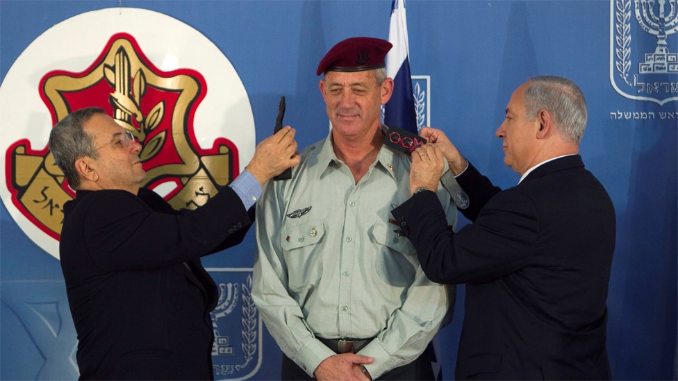 El ministro de Defensa de Israel Ehud Barak (izq) y el primer ministro Benjamín Netanyahu (der) cambian las charreteras del nuevo jefe del estado mayor de las IDF, Benny Gantz. 14 de febrero de 2011
