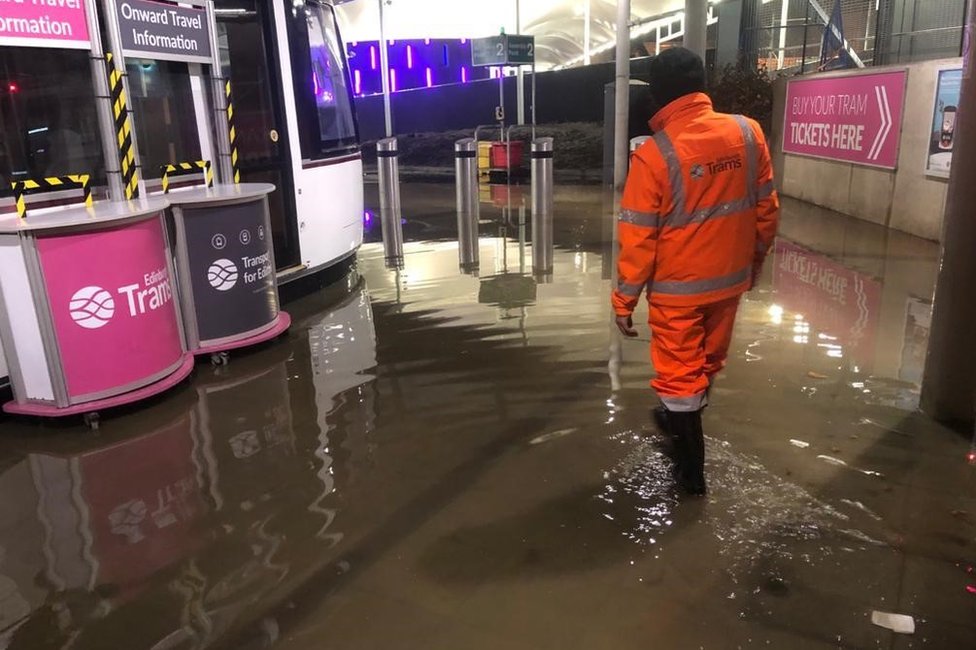 Рабочий на затопленной трамвайной остановке