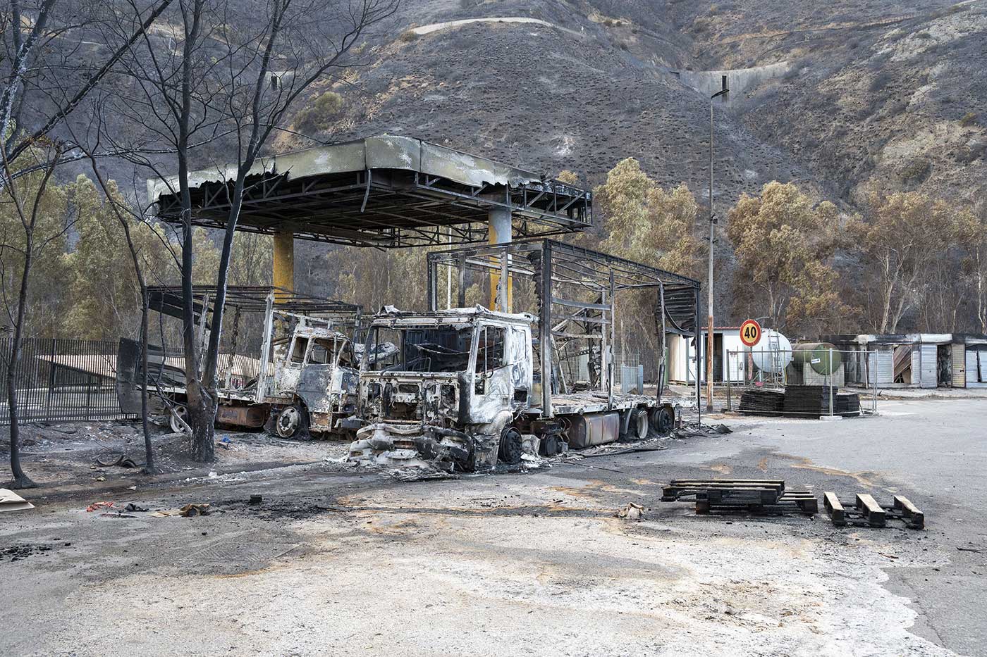 ​​Burnt vehicles sit on the forecourt of a destroyed petrol station on the Messina-Palermo motorway in the town of Oliveri, Sicily, after an overnight fire - 26 July 2023