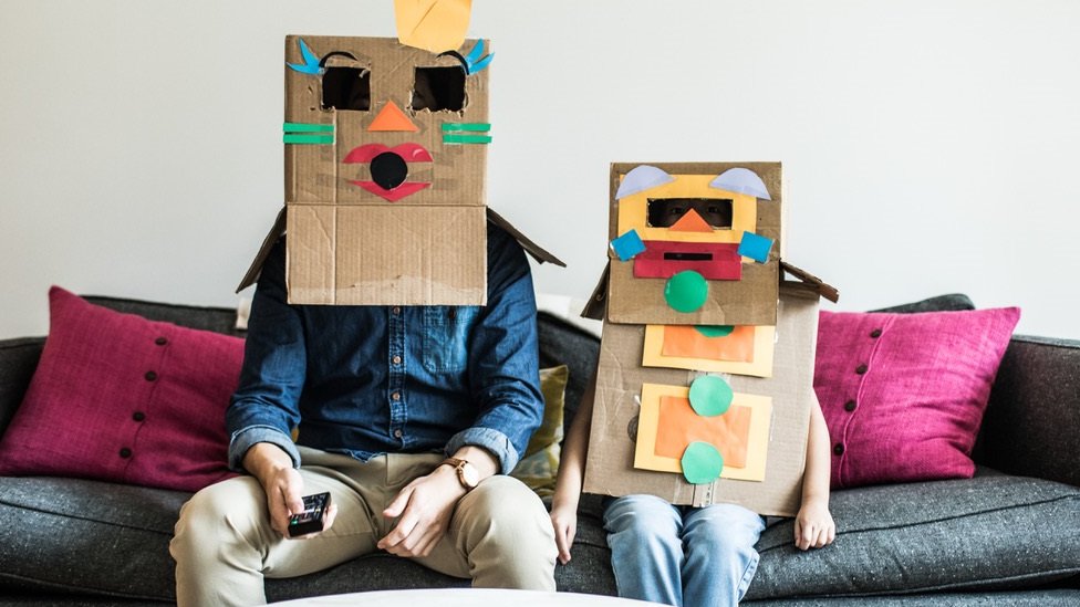 Man and child with boxes on their heads
