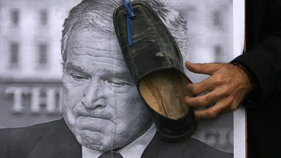Zapato contra una foto de Bush.