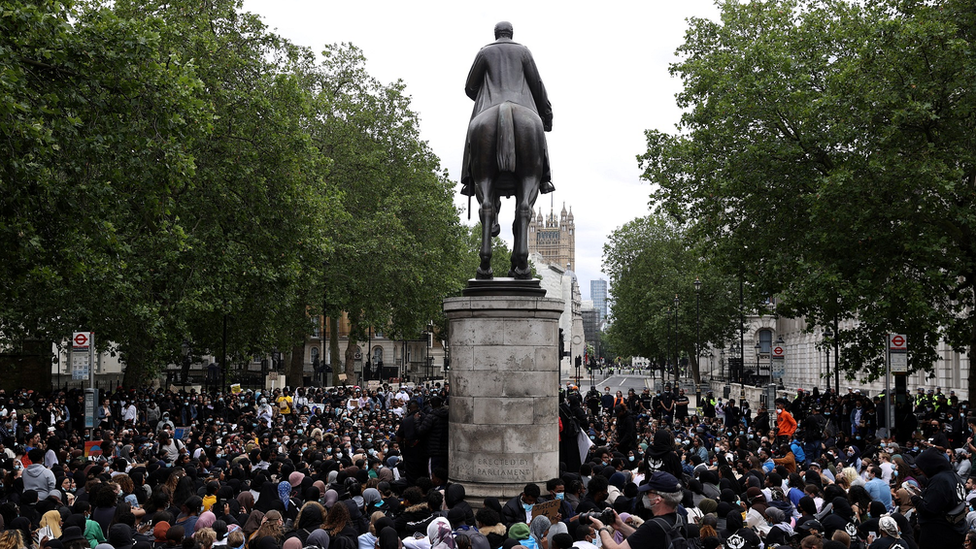 Демонстранты в Лондоне проходят мимо статуи