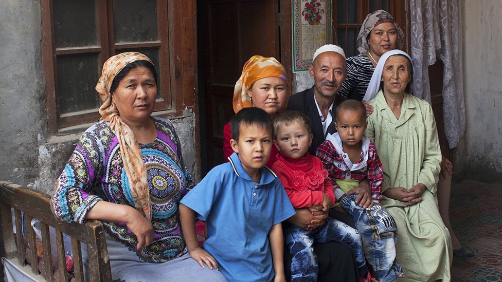 Keluarga Uighur di depan rumah mereka