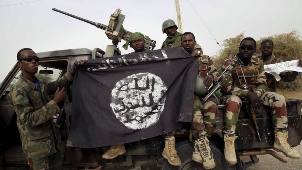Нигерийские солдаты держат флаг Боко Харам, захваченный в 2015 году