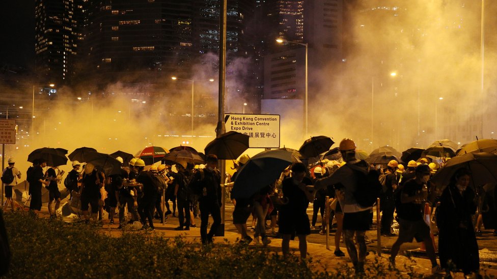 Протестующие собираются в кучу под слезоточивым газом