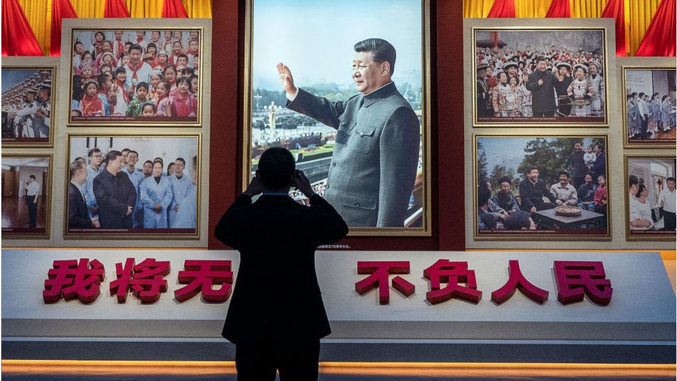 Un visitante toma una foto de un cuadro de Mao Zedong.