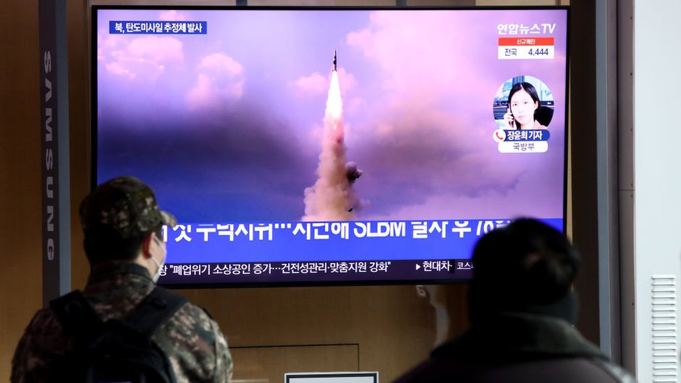 شخصان يشاهدان تلفازا يعرض صورة لإطلاق صاروخ كوري شمالي، في 5 يناير/كانون الثاني 2022 في سيول، كوريا الجنوبية