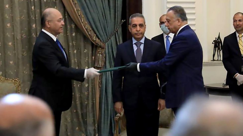 Президент Бархам Салех (слева) и Мостафа аль- (справа) на церемонии были в перчатках