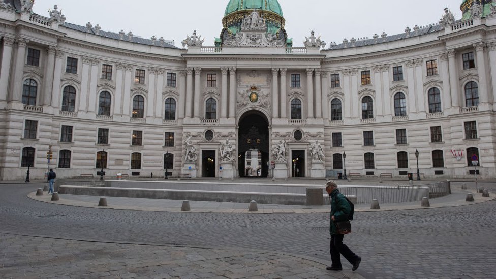 A man crosses Michaelerplatz in front of the Hofburg palace on the first day of a nationwide, temporary lockdown during the fourth wave of the novel coronavirus pandemic on 22 November