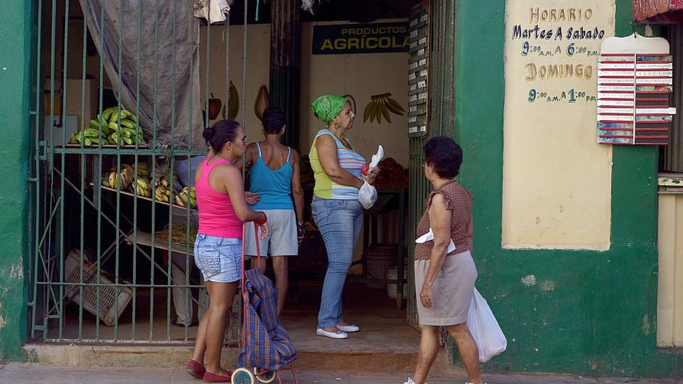 Mujeres hacen cola en un mercado.