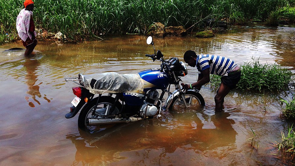 2014年埃博拉疫情爆發期間，一名男子在利比里亞首都蒙羅維亞浸水的路上洗車。