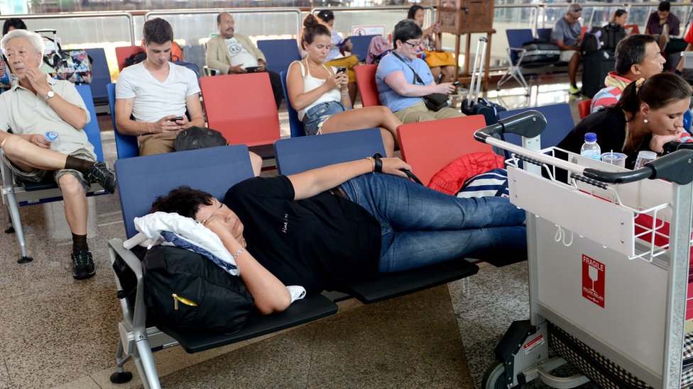 Пассажиры ждут информации о задержанных и отмененных рейсах в международной зоне вылета аэропорта Нгурах-Рай на Бали в Денпасаре 4 ноября