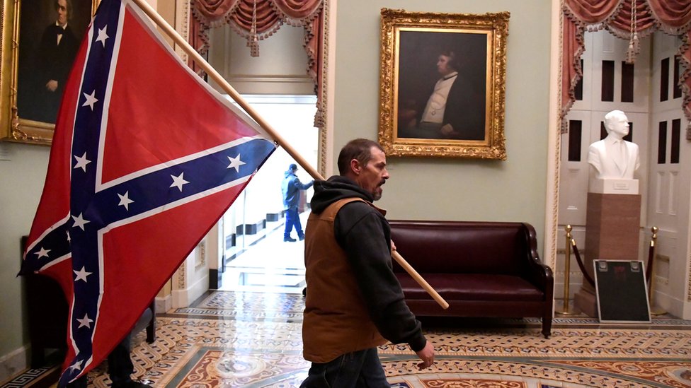 A protester carries the Confederate flag into the US Capitol building