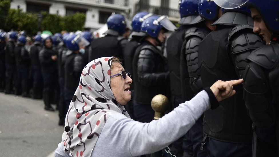 Starija žena priča sa alžirskim snagama bezbednosti tokom skorašnjih protesta