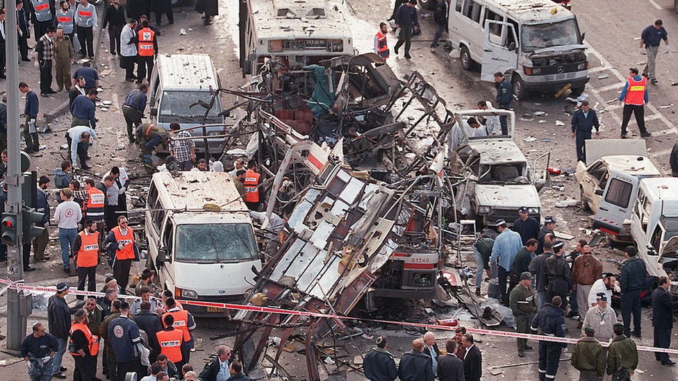 Israeli rescue teams look inside the wreckage of a bus destroyed by a bomb explosion on 25 February 1996 in Jerusalem