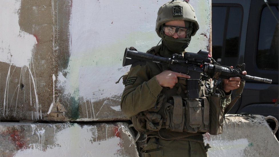 جندي إسرائيلي مسلح يراقب في بلدة حوارة بالضفة الغربية، بالقرب من مدينة نابلس، 28 فبراير/شباط 2023.