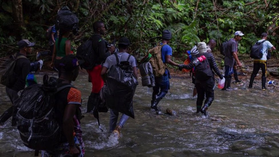 Migranti prelaze reku Darijan između Kolumbije i Paname