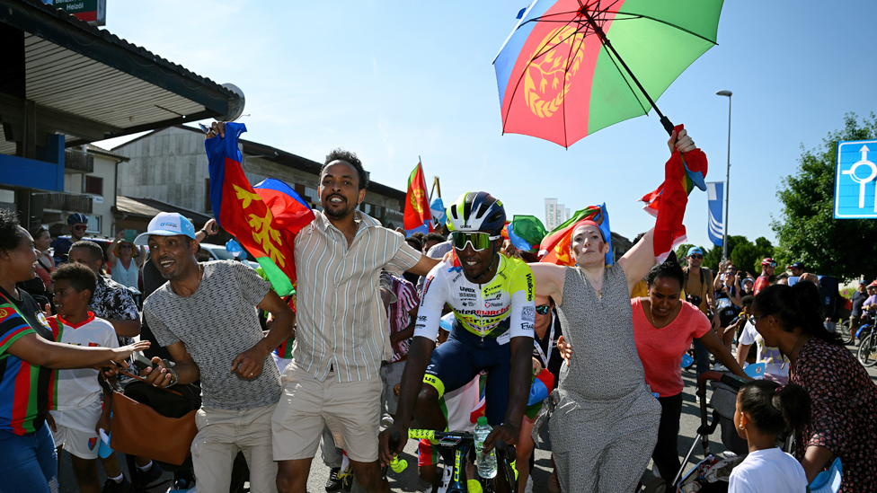 اليوم التالي، الدراج الإريتري، بنيام غيرماي، يحتفل مع مشجعيه، بعد فوزه بالجولة الثانية في سباق سويسرا الدولي