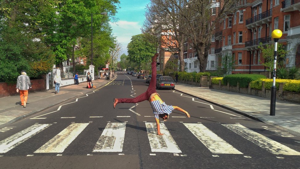 Júlio Andrade does a handstand on the Abbey Road crossing.