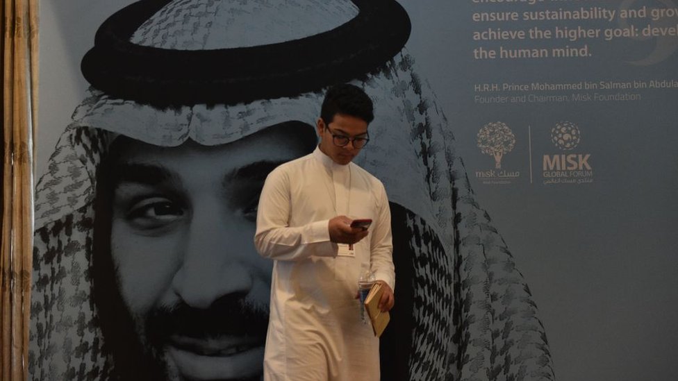 Делегат экономической конференции перед портретом наследного принца Саудовской Аравии Мохаммеда бин Салмана в Эр-Рияде (фото из архива)