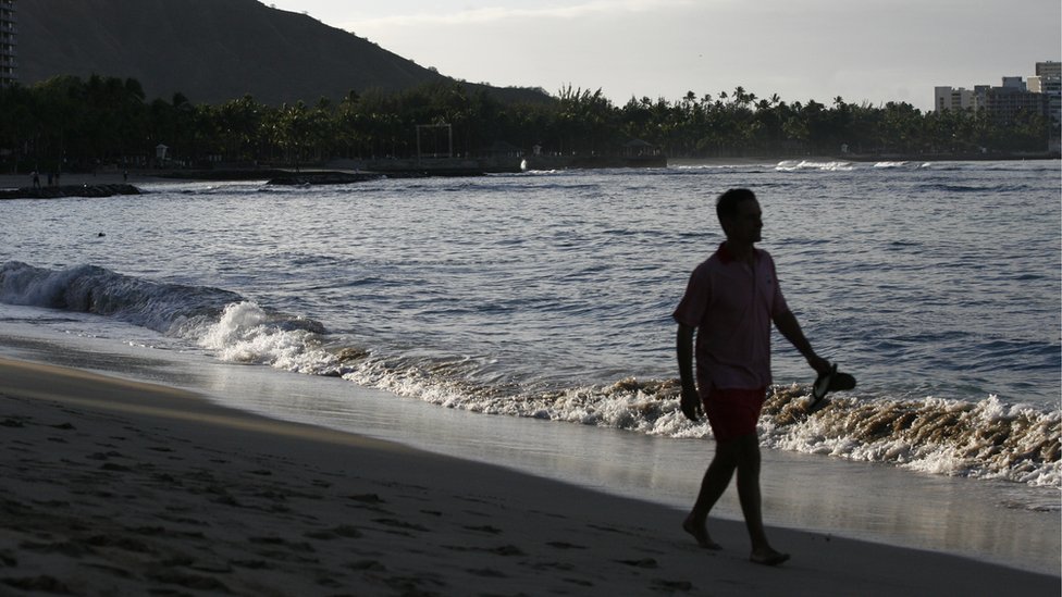 Un hombre camina por Playa Waikiki, en Honolulu. Las autoridades calculan que, si hay un ataque norcoreano, los habitantes de Hawái tendrían un cuarto de hora escaso para ponerse a cubierto. Un hombre camina por Playa Waikiki, Honolulu.