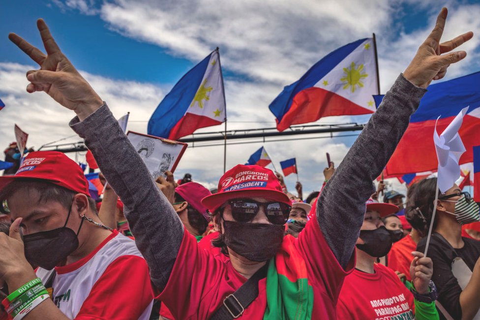 A supporter flashes the peace sign, the campaign symbol of Ferdinand "Bongbong" Marcos Jr., during his last campaign rally before the election on May 07, 2022 in Paranaque, Metro Manila, Philippines.