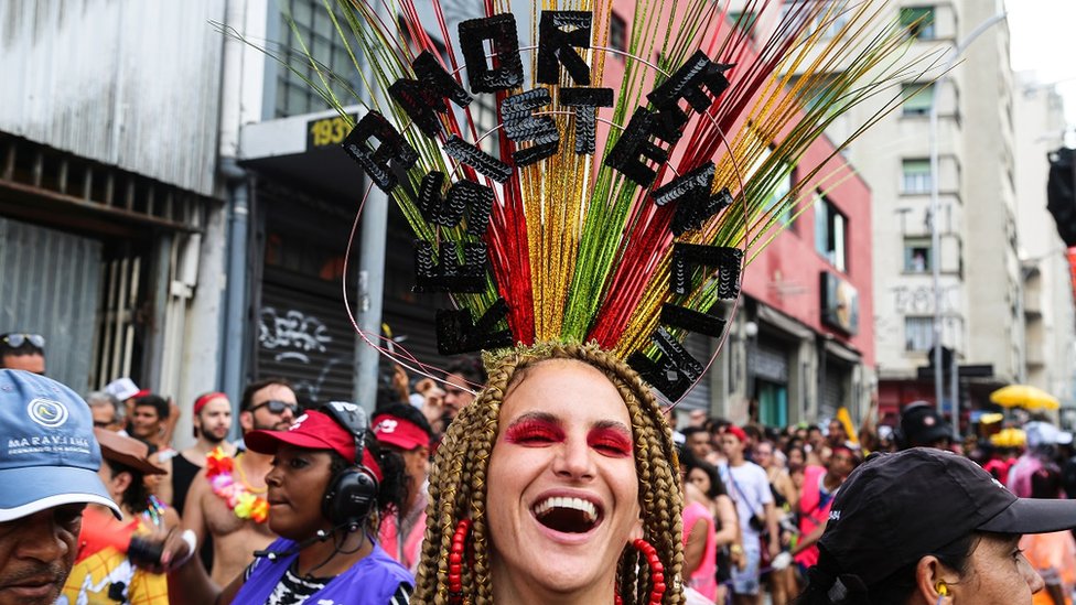 Una de las participantes del carnaval lleva un tocado decorado con la frase "Amor y resistencia".