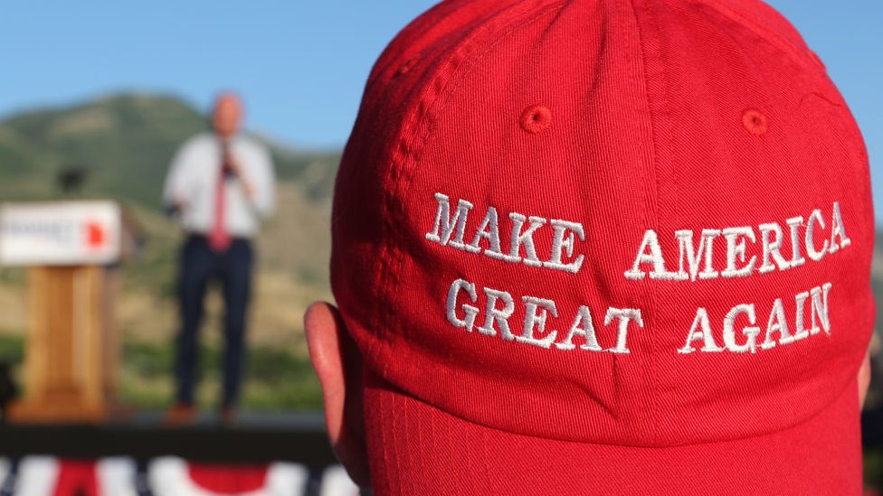Un hombre usa una gorra con el lema de Trump 