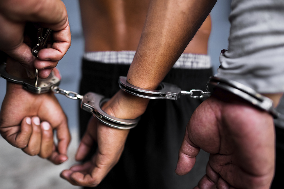 Two men are handcuffed in a prison in El Salvador