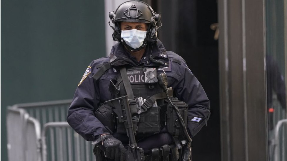 Вооруженный офицер в Нью-Йорке стоит на страже возле Башни Трампа в маске