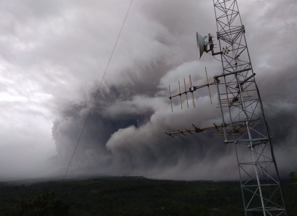 На фотографии, сделанной Национальным советом Индонезии по борьбе со стихийными бедствиями, видно, как пепел покрывает ландшафт