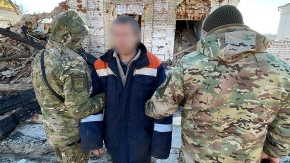 The Russian soldier (centre) is detained by two members of Ukraine's armed forces in Kupiansk, Ukraine