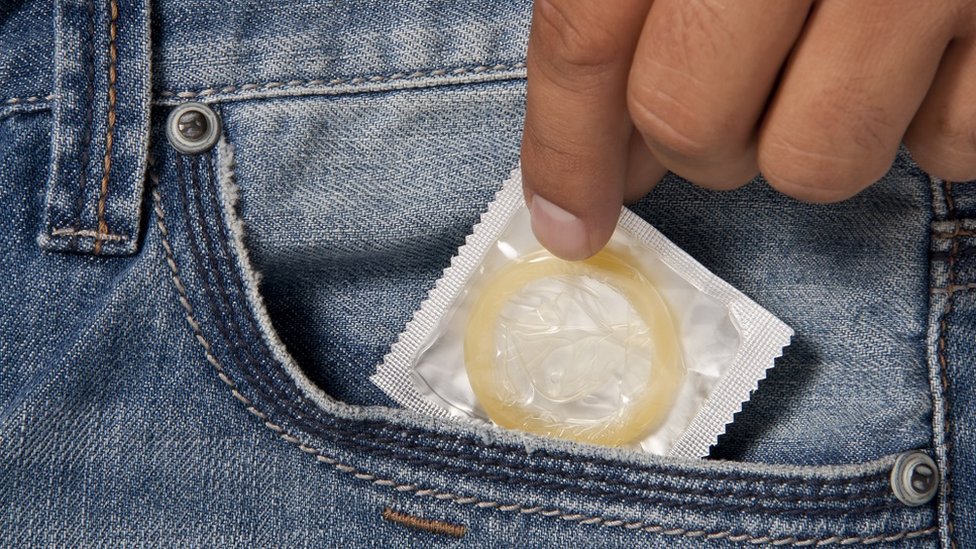 Homem tira preservativo do bolso da calça
