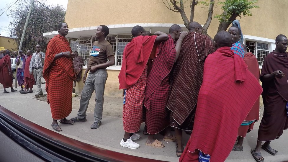 Уличные торговцы танзанитами, одетые в одежду масаев