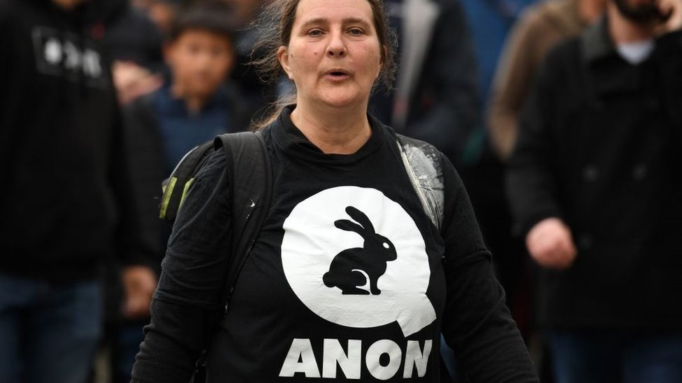 Mulher com camisa com o logo da QAnon