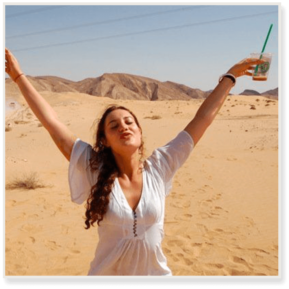 A photograph of Constance Marten standing with her arms outstretched in a desert in the background