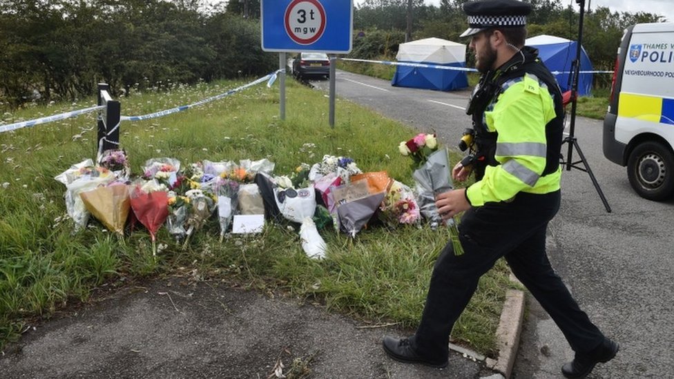 Полицейский возлагает на месте происшествия цветы