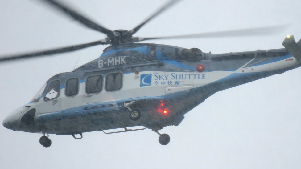 一架空中快線AW139型直升機在雨中從香港港澳碼頭起飛前往澳門（BBC中文圖片13/6/2018）
