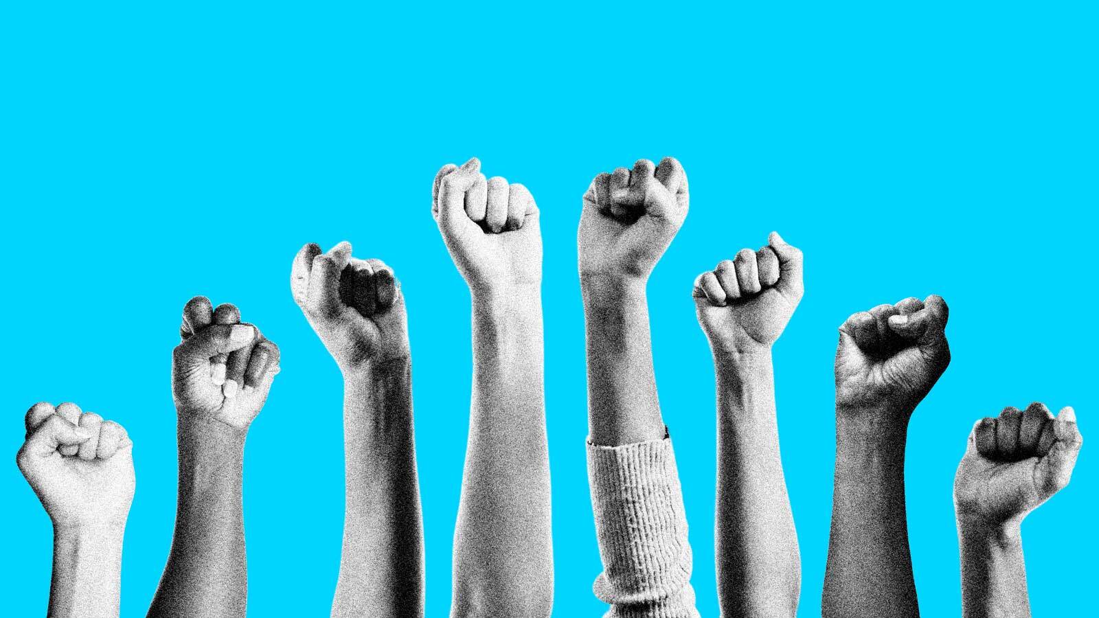 A group of fists raised to the sky against a bright blue background