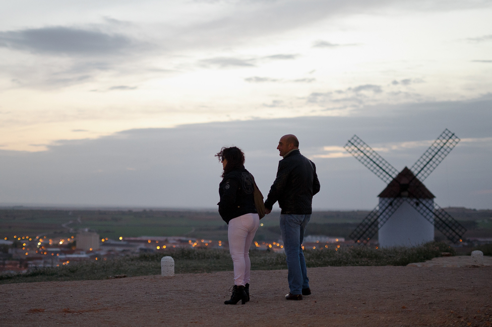 Man and woman photographed near a windmill in Mota del Cuervo