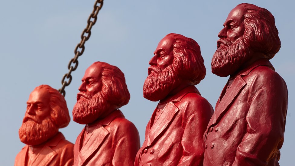 Es como si diferentes Marx hubiesen escrito versiones distintas de las traducciones. Cuatro estatuas rojas de Karl Marx.
