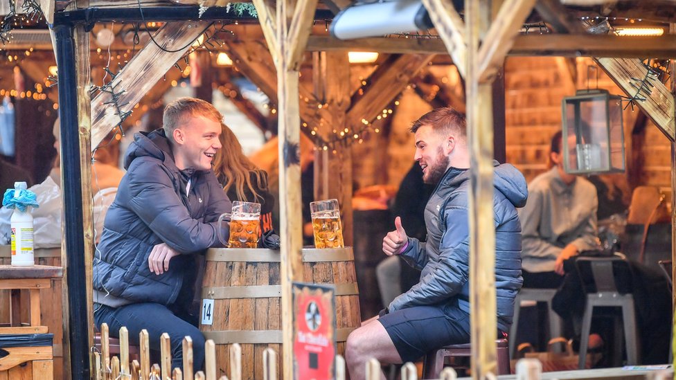 Two men drinking in a pub at a Christmas market