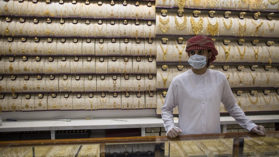 Продавец носит защитную маску в магазине золота на Dubai Gold Market, Дубай