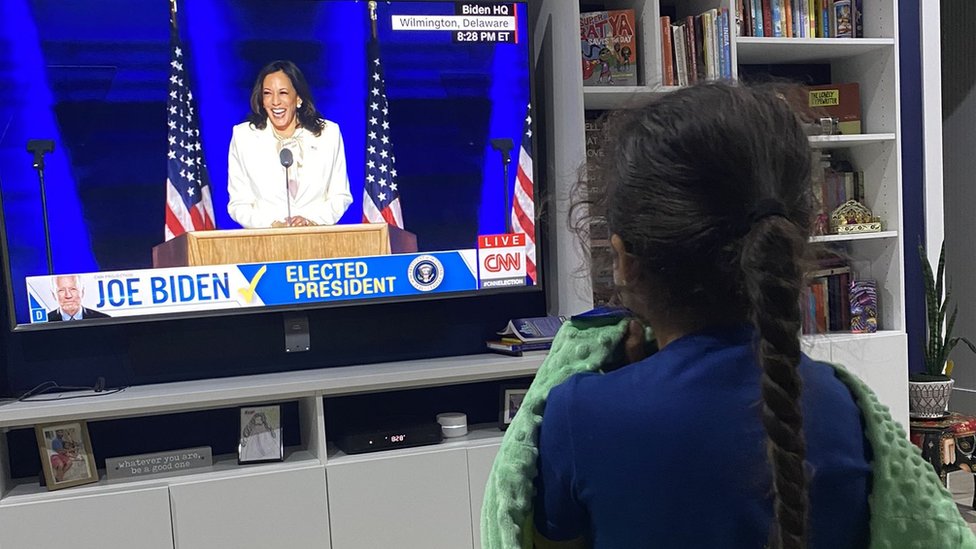 Una niña observa el discurso de Kamala Harris en televisión