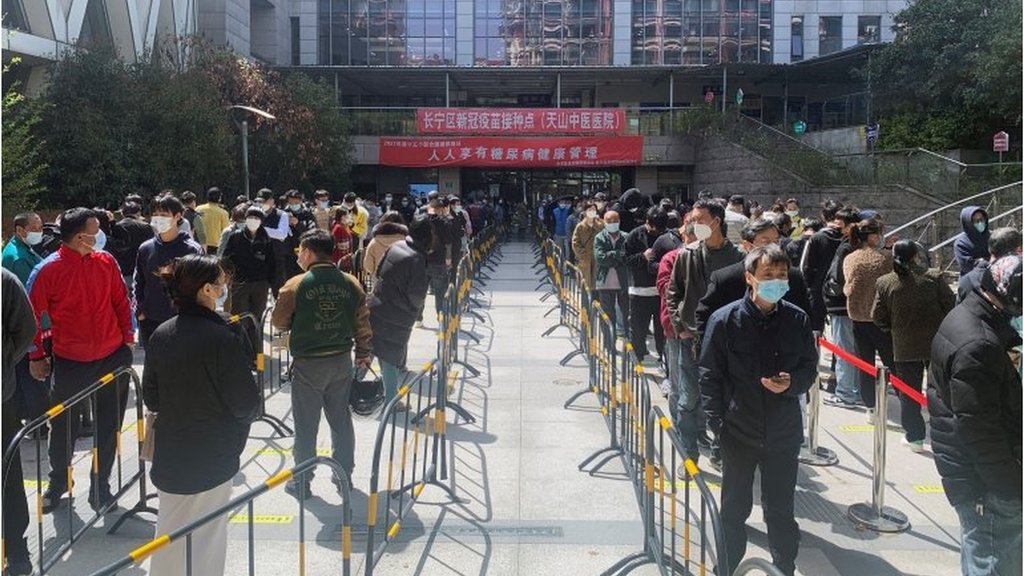 上海長寧區，人們在醫院排隊進行核酸檢測。