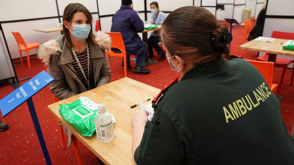 A woman gives her details before getting a Covid jab in Newcastle