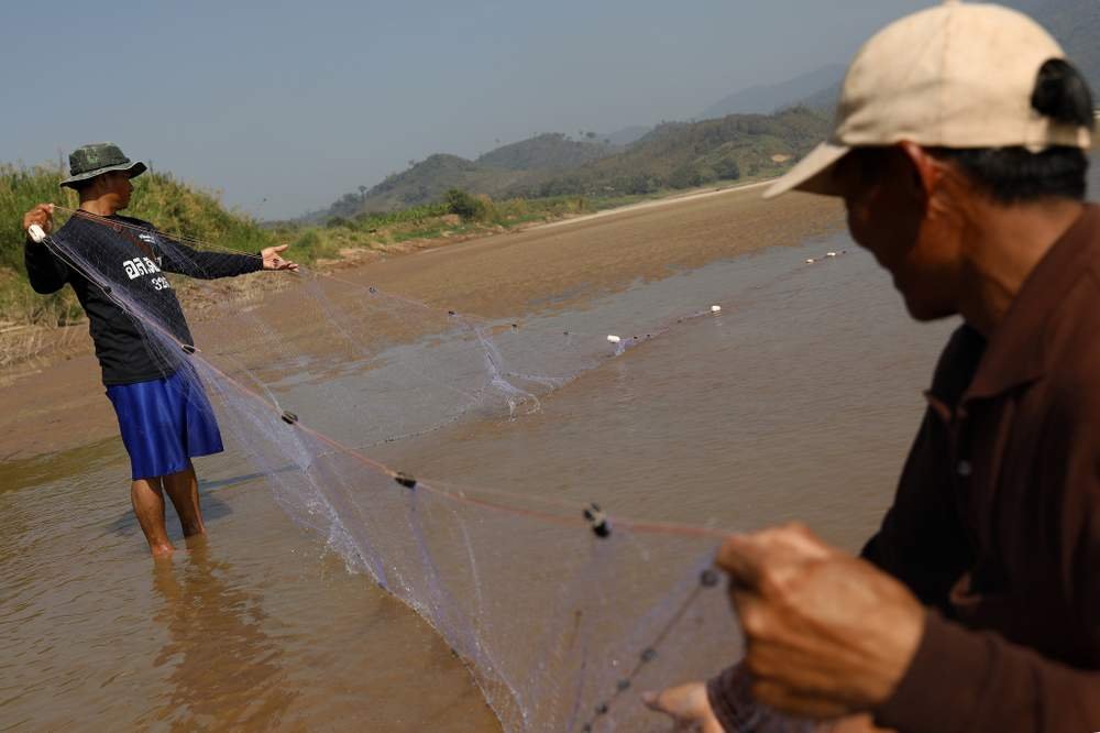 泰國漁民在位於泰國最北部地區的湄公河撒網捕魚。