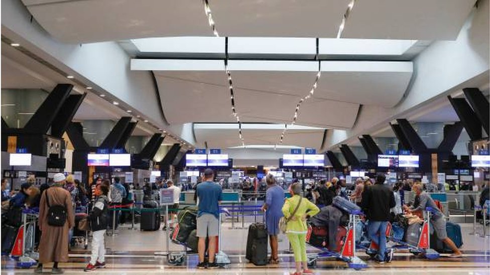 مسافرون في مطار "أو أر تامبو" الدولي في جوهانسبيرغ ينتظرون الخروج من البلاد بعد أن ألغت بعض شركات الطيرات رحلاتها إلى بعض الدول.