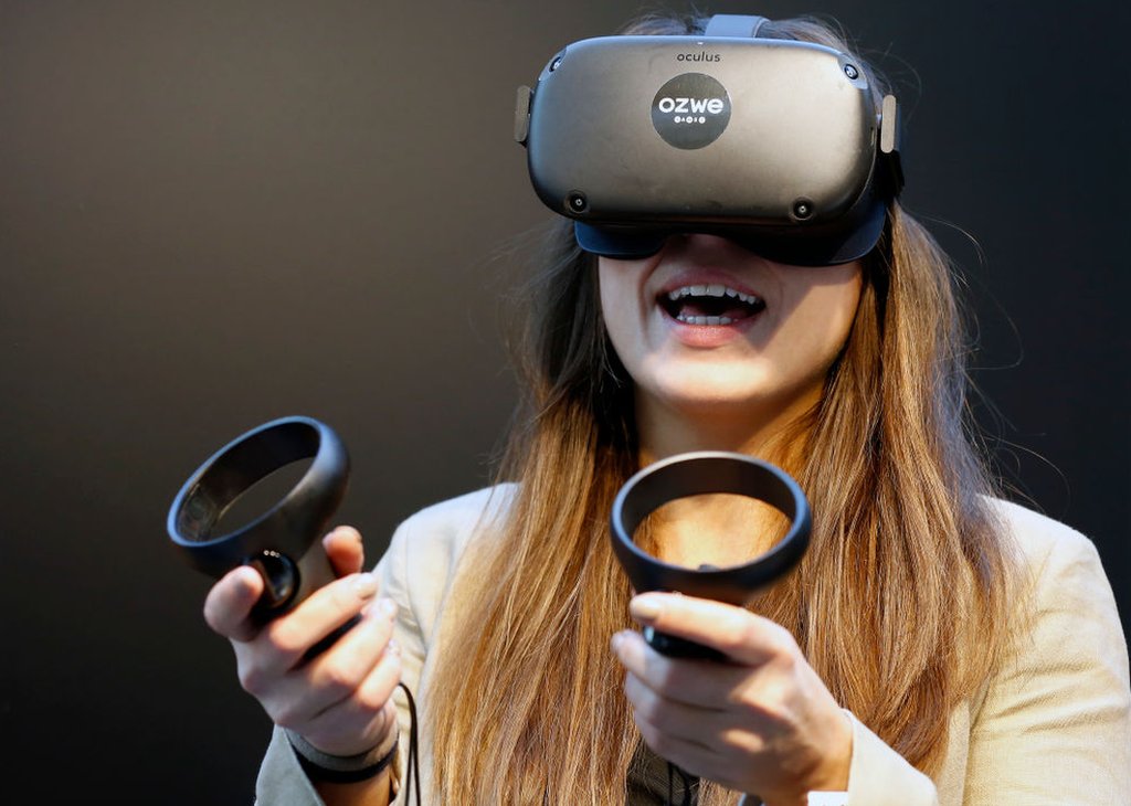 Una mujer usando un visor de realidad virtual.