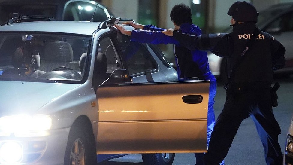 Armed policemen search a person near the Schwedenplatz in the centre of Vienna on November 2, 2020